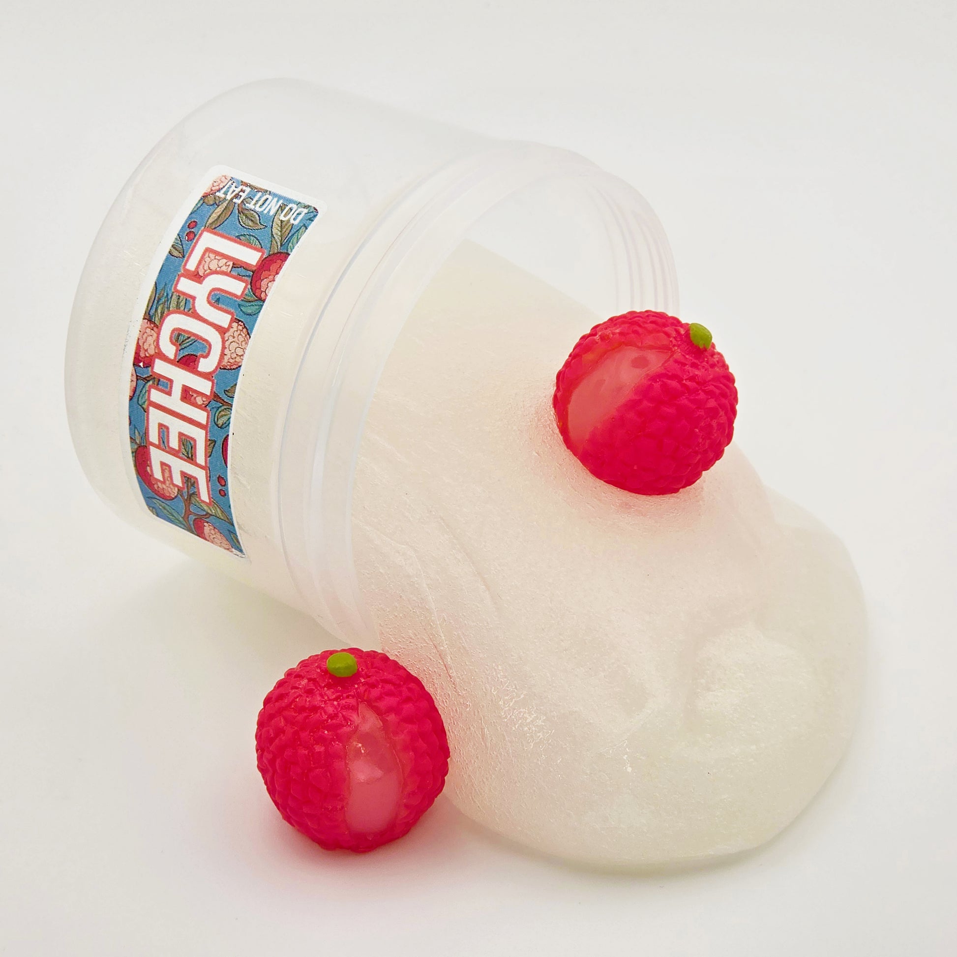 slime container with lychee slime pouring out with lychee charms on a white background
